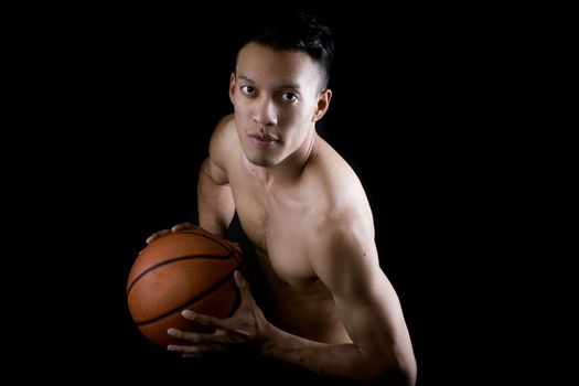 Asian young basketball player on black background