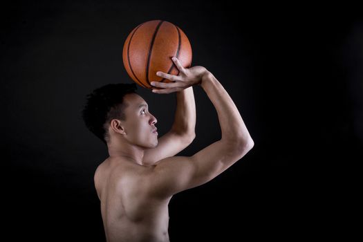 Asian young basketball player on black background