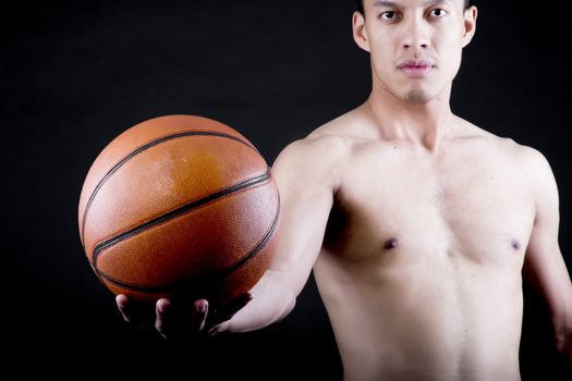 Asian young basketball player on black background