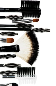 Vertical Frame of Various Make-up Brushes and Applicators closeup on white background