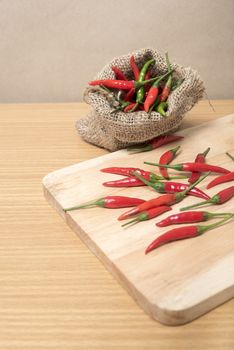 red chili peppers on cutting board over wood table background