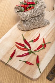 red chili peppers on cutting board over wood table background