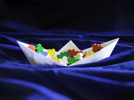 Immigration emigration migration conceptualization, white paper boat full of colorful meeples, refugee crisis topic illustration and social issues symbol
