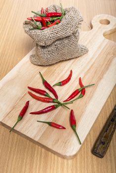 red chili peppers on cutting board over wood table background