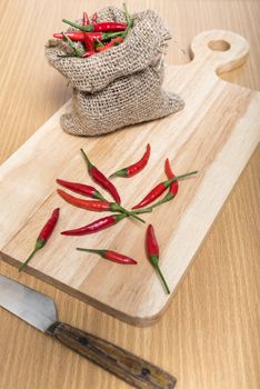 red chili peppers on cutting board over wood table background