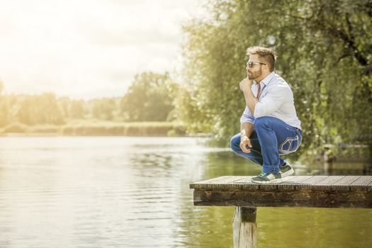 An image of a bearded man at the lake