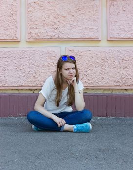 girl in jeans sitting on the ground