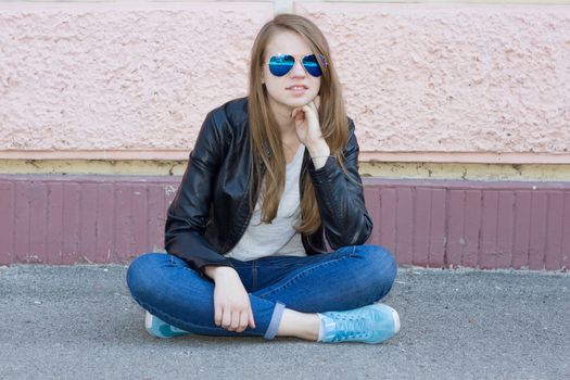 girl in jeans sitting on the ground