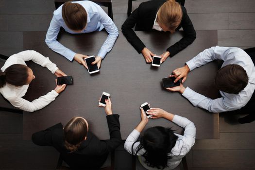 business people at the desk with mobile phones