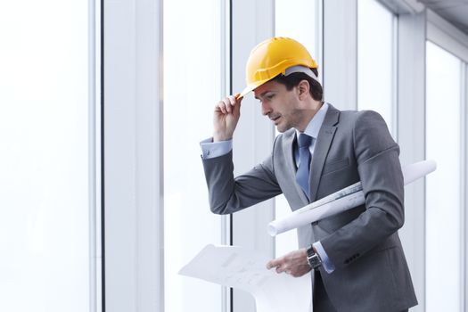 Architector in hardhat and business suit with construction plans