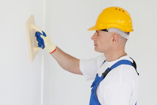 portrait of workman polishing wall