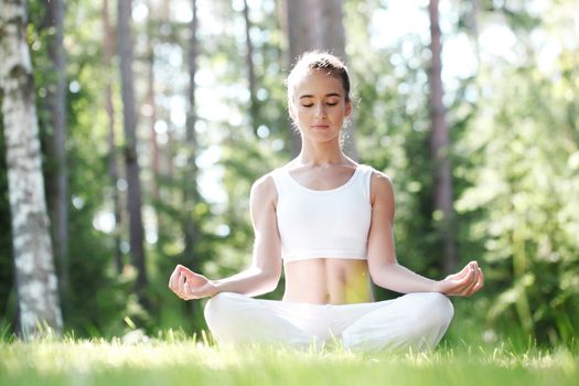 beautiful young woman doing yoga at park