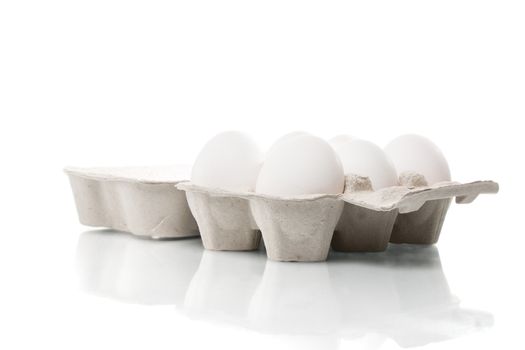 Six white chicken eggs in an egg box