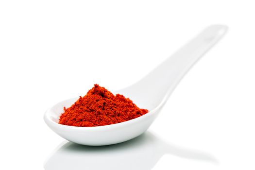 Paprika (Capsicum) powder on porcelain spoons, isolated