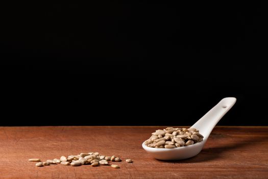 Sunflower seed threads on a white porcelain spoon