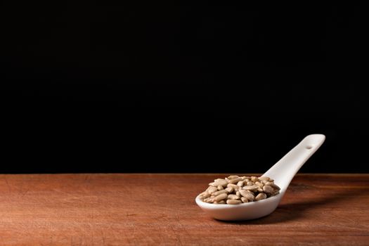 Sunflower seed threads on a white porcelain spoon