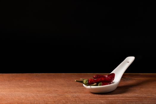 Chili (Capsicum)  threads on a white porcelain spoon