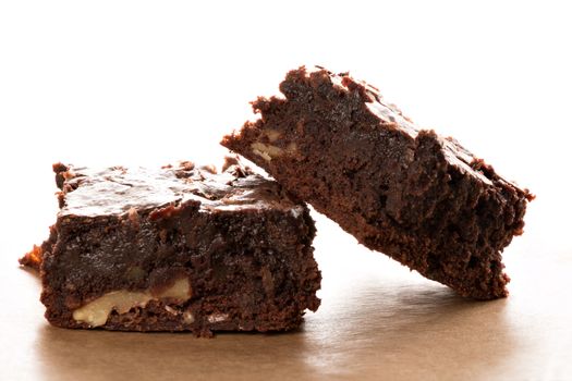 Freshly baked brownies are, served on a piece of baking paper