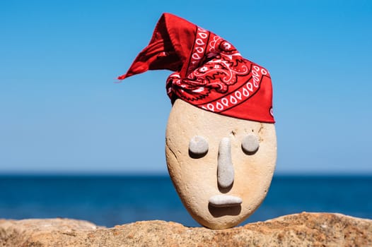 Image of stone head with a patterned red bandana