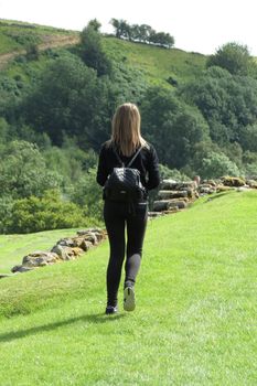 HEXHAM, UK - CIRCA AUGUST 2015: unidentified girl dressed in black walking on the grass