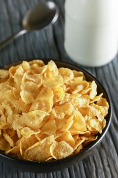 cornflakes with milk on wooden table