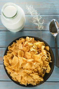 cornflakes with milk on wooden table