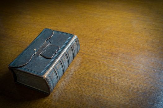 Closed 18th century Bible-Songbook on an old wooden table