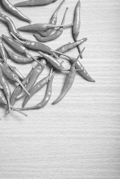 red chili peppers on wood table background black and white tone color style