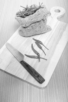 red chili peppers on cutting board over wood table background black and white tone color style