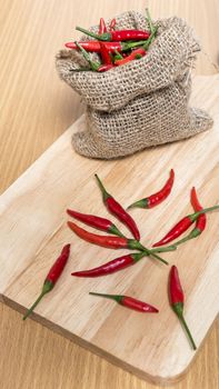 red chili peppers on cutting board over wood table background