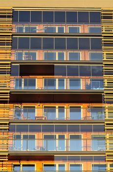 Balconies on the side of a building with many windows.