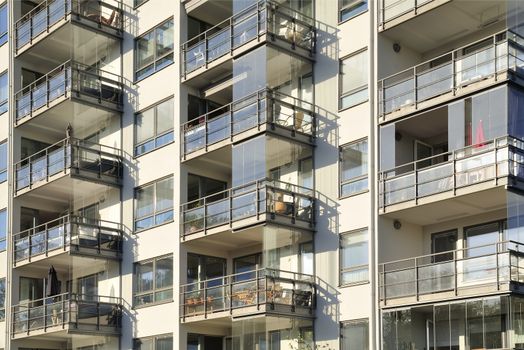 Balconies on the side of a building with many windows.