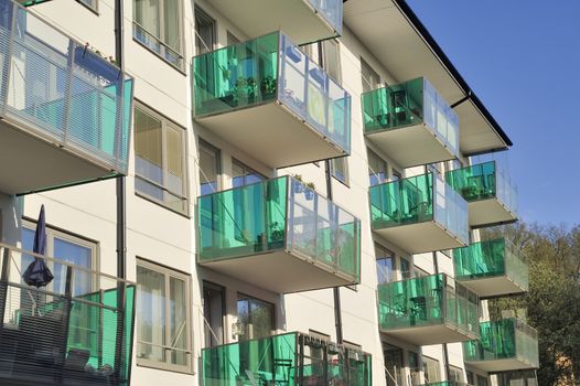 Balconies on the side of a building with many windows.