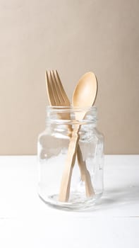 wood spoon and fork with glass over white table