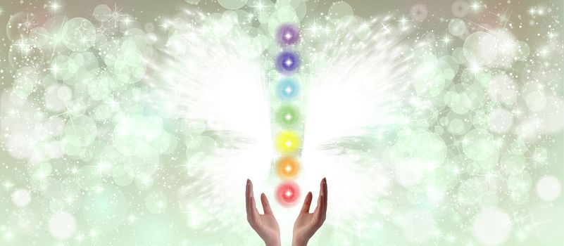 Healing Hands and seven chakras on a sparkling pastel coloured background