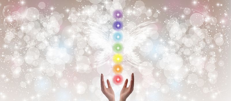 Healing Hands and seven chakras on a sparkling pastel coloured background
