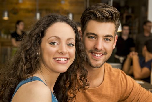 Happy couple at the restaurant talking and smiling