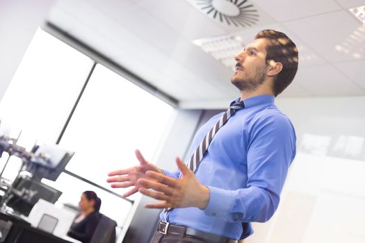 Business man making a presentation at office. Business executive delivering a presentation to his colleagues during meeting or in-house business training. Business and entrepreneurship.