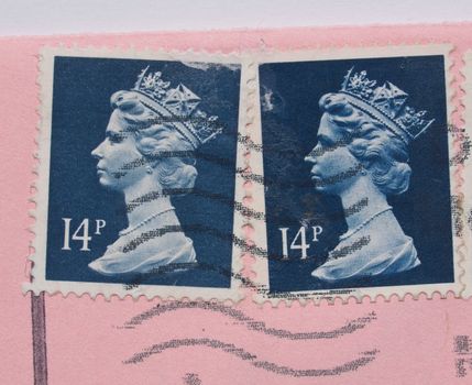 LONDON, UNITED KINGDOM - MAY 23, 2015: Stamps printed by United Kingdom bearing the portrait of the Queen over a pink envelope