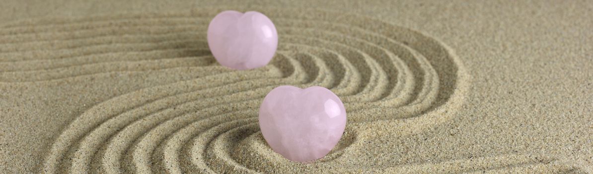 Rose quartz hearts placed in zen garden