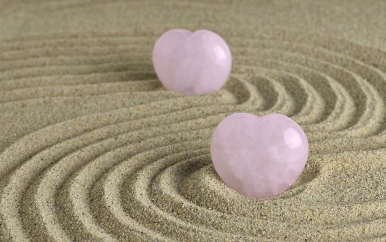 Rose quartz hearts placed in zen garden
