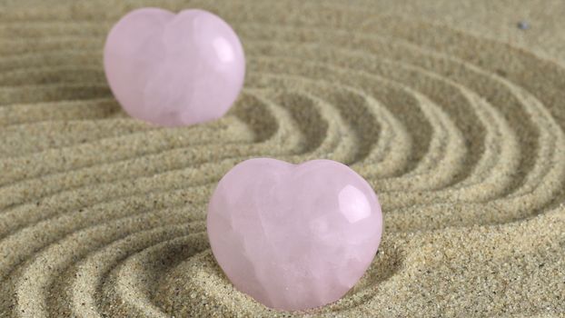 Rose quartz hearts placed in zen garden