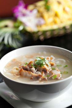 Closeup top down view of Thai style crispy pork rice noodle soup in a bowl with copy space.