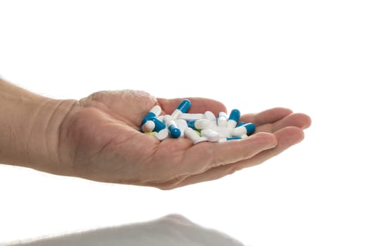 Man holding a handful of tablets, isolated