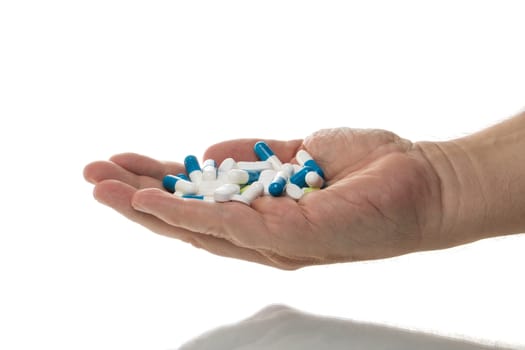 Man holding a handful of tablets, isolated