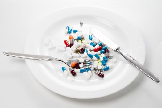 Tablets served on a white plate with knife and fork