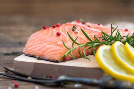 Raw Salmon Fish Fillet with Lemon, Spices and Fresh Herbs on Cutting Board Ready to Cook