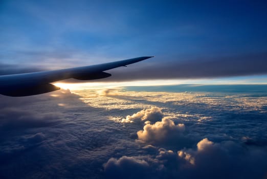 August 2015.Fly from Singapore to Houston.View of the right wing passenger aircraft.Below the thick clouds illuminated by the sun.Horizontal view