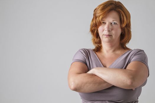 woman in her forties with her arms cross and a serious look