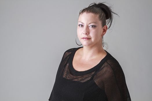 Woman in her mid-thirties wearing a black transparent shirt